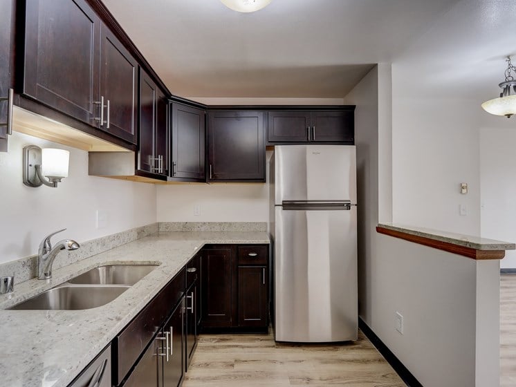 a kitchen with dark cabinets and a white refrigerator